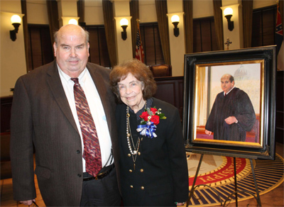 Judge James L. Roberts Jr. poses with portrait
